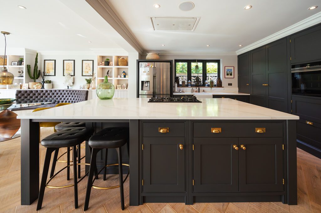 Luxurious kitchen design showcasing a spacious island with seating for four, high-end appliances, and a sleek black and gold color scheme.